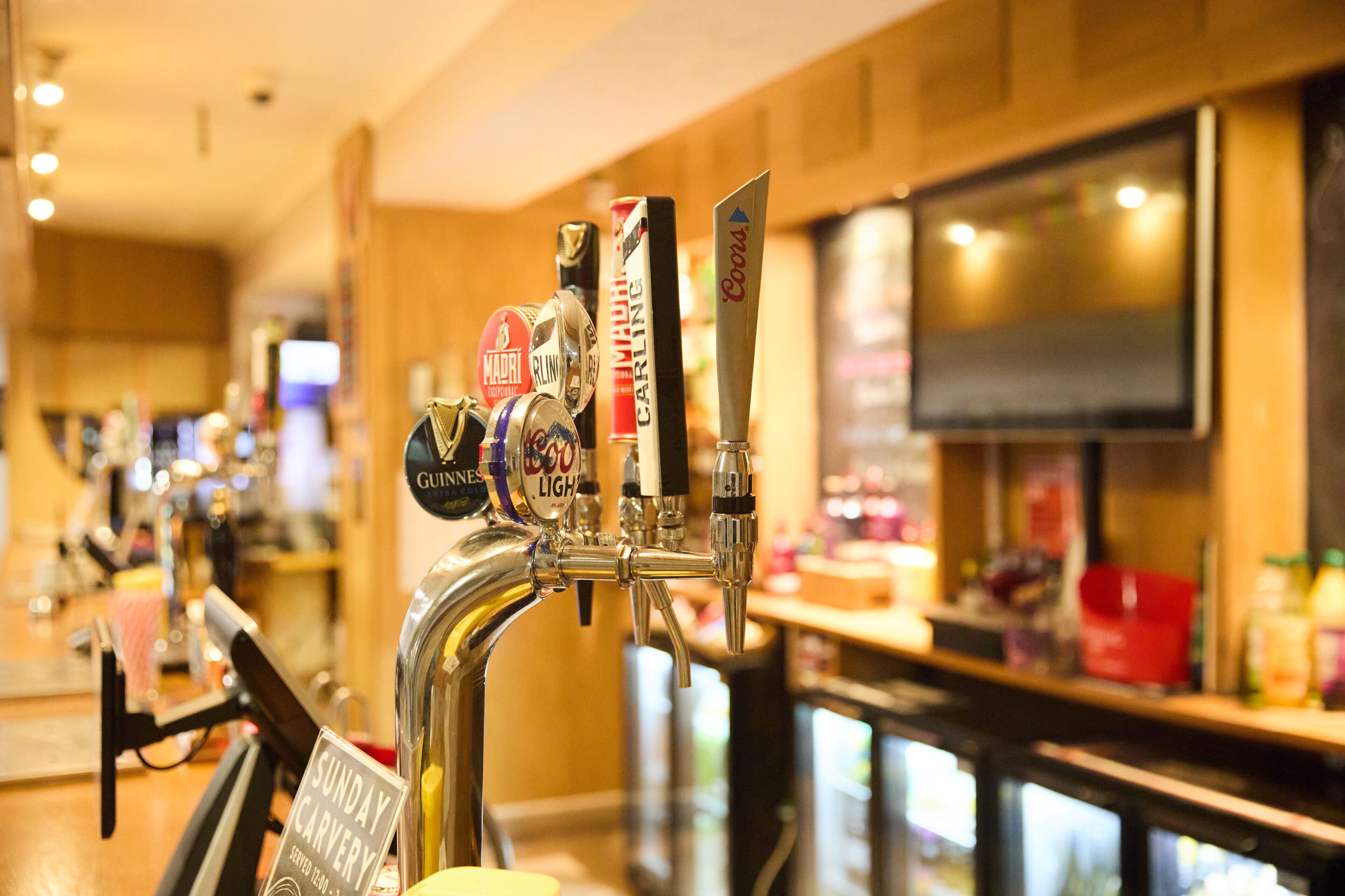 Un bar con varias griferías, incluyendo marcas como Guinness y Carlsberg.