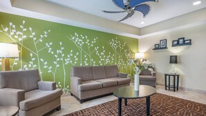 Un salon moderne avec un canapé beige, une table basse ronde et un tapis à motifs.