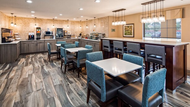 A restaurant with a bar area, seating, and kitchen appliances. - Best Western Lafayette Inn (Lafayette)