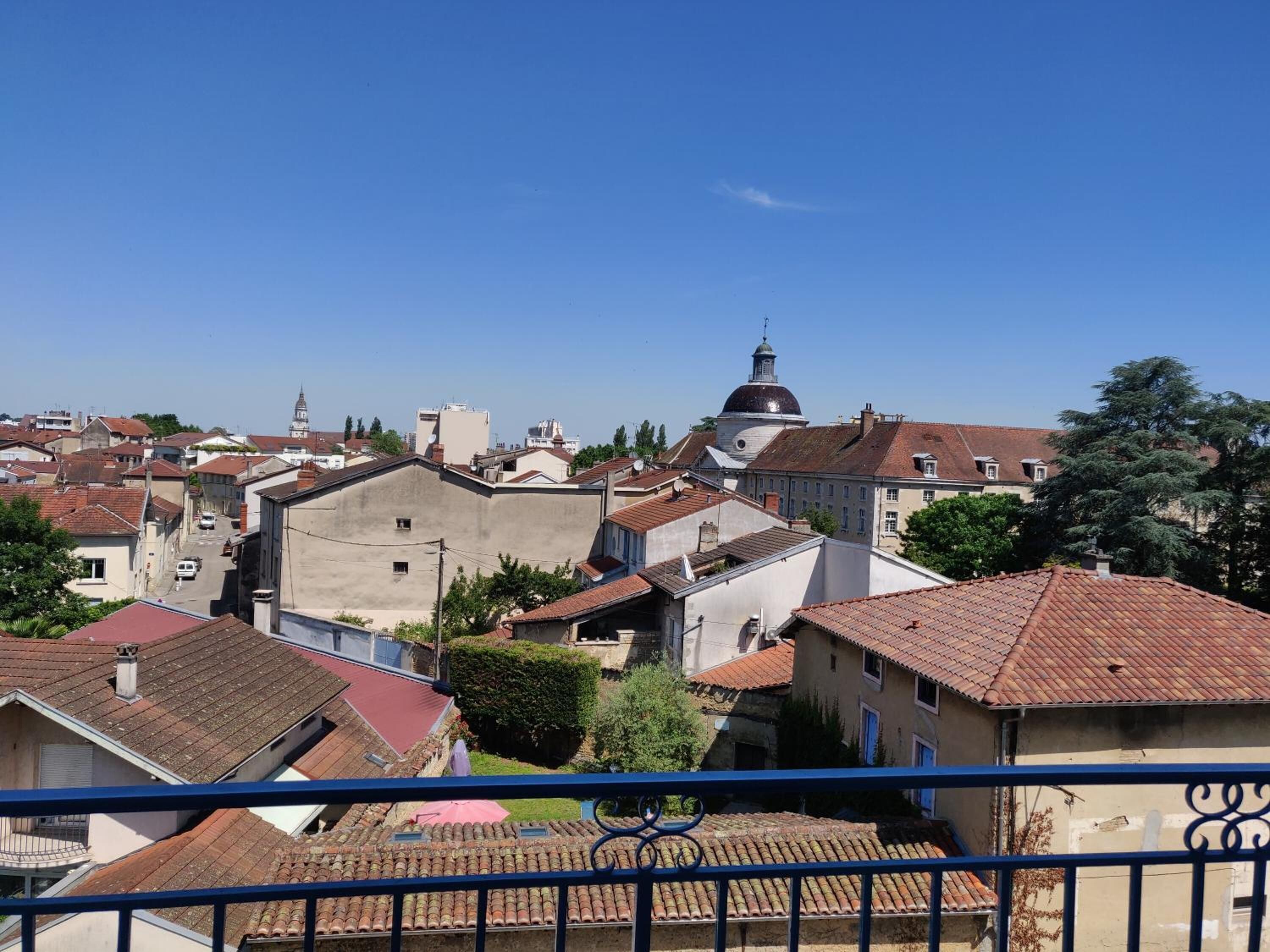A residential area with a prominent church with a dome and a bell tower, surrounded by houses with red-tiled roofs.