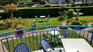 A patio area with blue and white patterned chairs and a table, surrounded by a blue railing.
