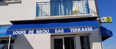 A building with balconies and a bar named "Logis de Brou Bar Terrasse".