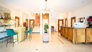 A spacious kitchen with a central island, bar stools, and a modern chandelier. - Cit'Hotel Logis de Brou (Bourg-en-Bresse)