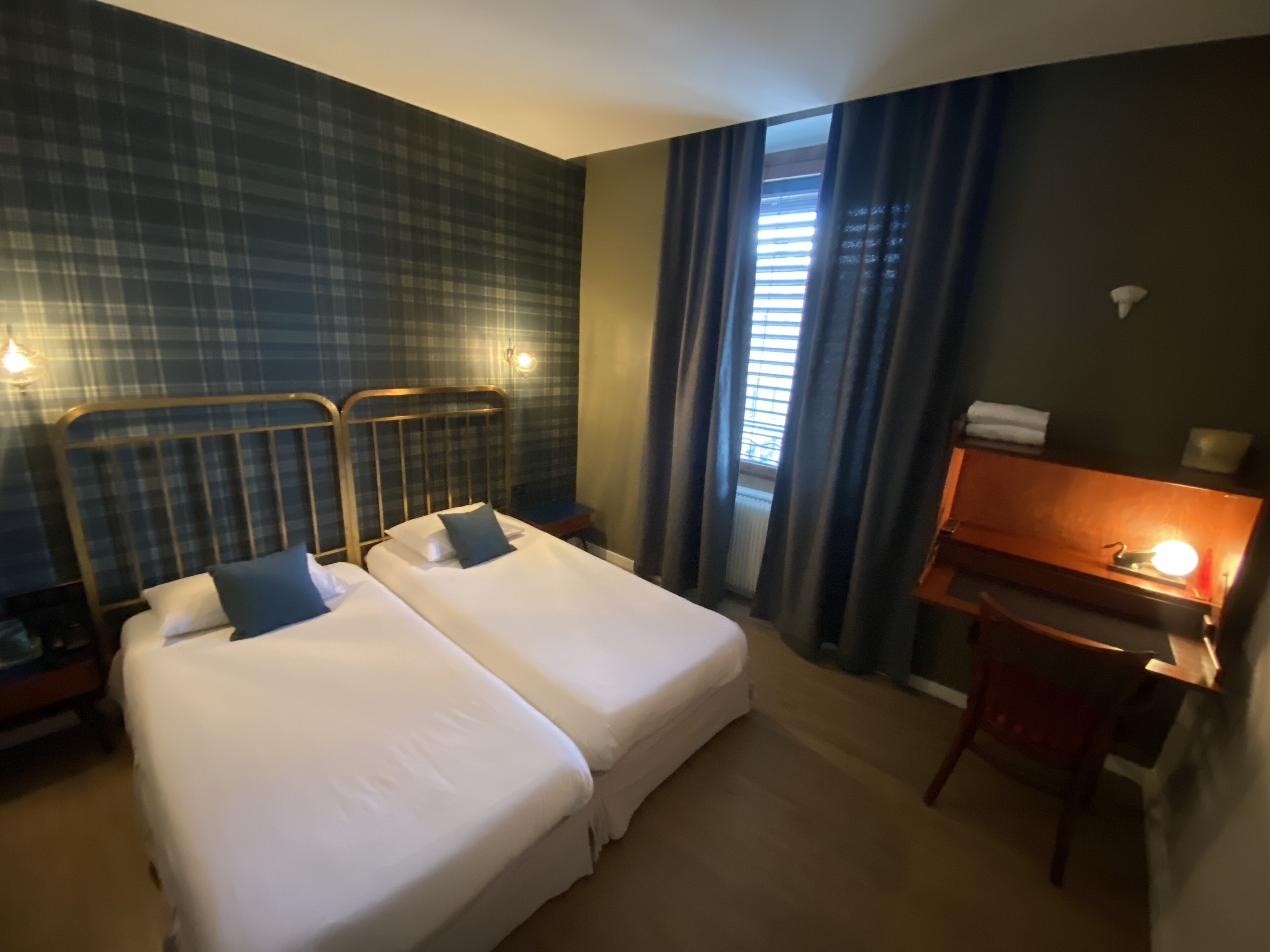 Habitación de hotel con dos camas, un escritorio y una silla.
