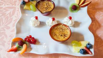 Un plato de postre con diversas frutas y crema batida.