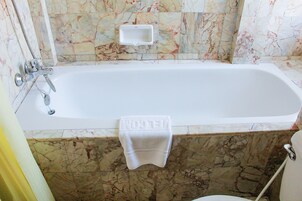 A bathroom with a bathtub, a shower, and a toilet.