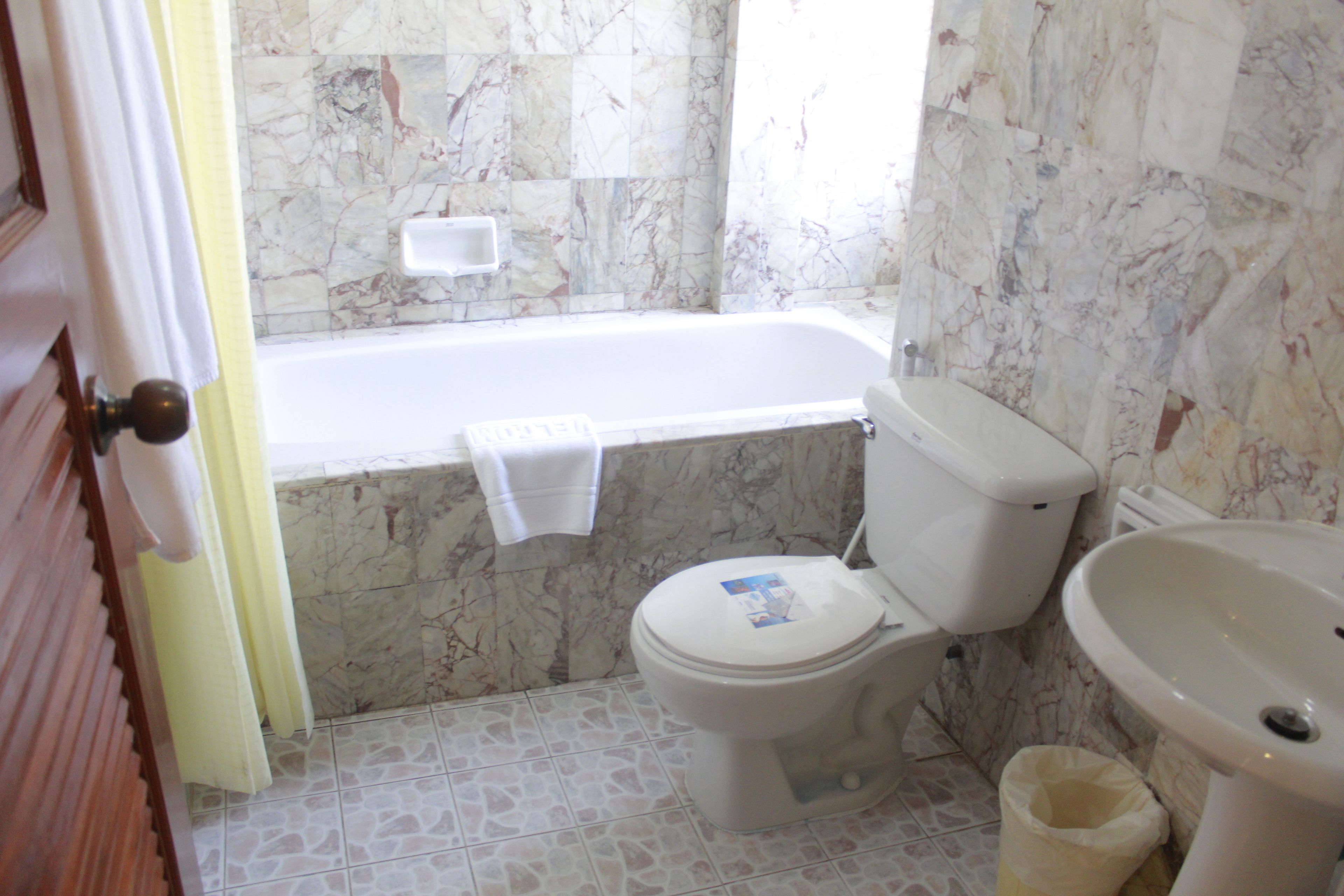 A bathroom with a toilet, bathtub, and sink.
