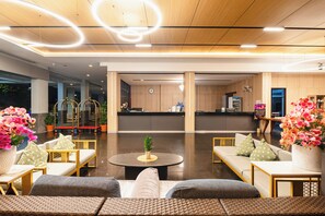A modern lobby with seating areas, a reception desk, and decorative plants. - Casa Del M Phuket (Patong)