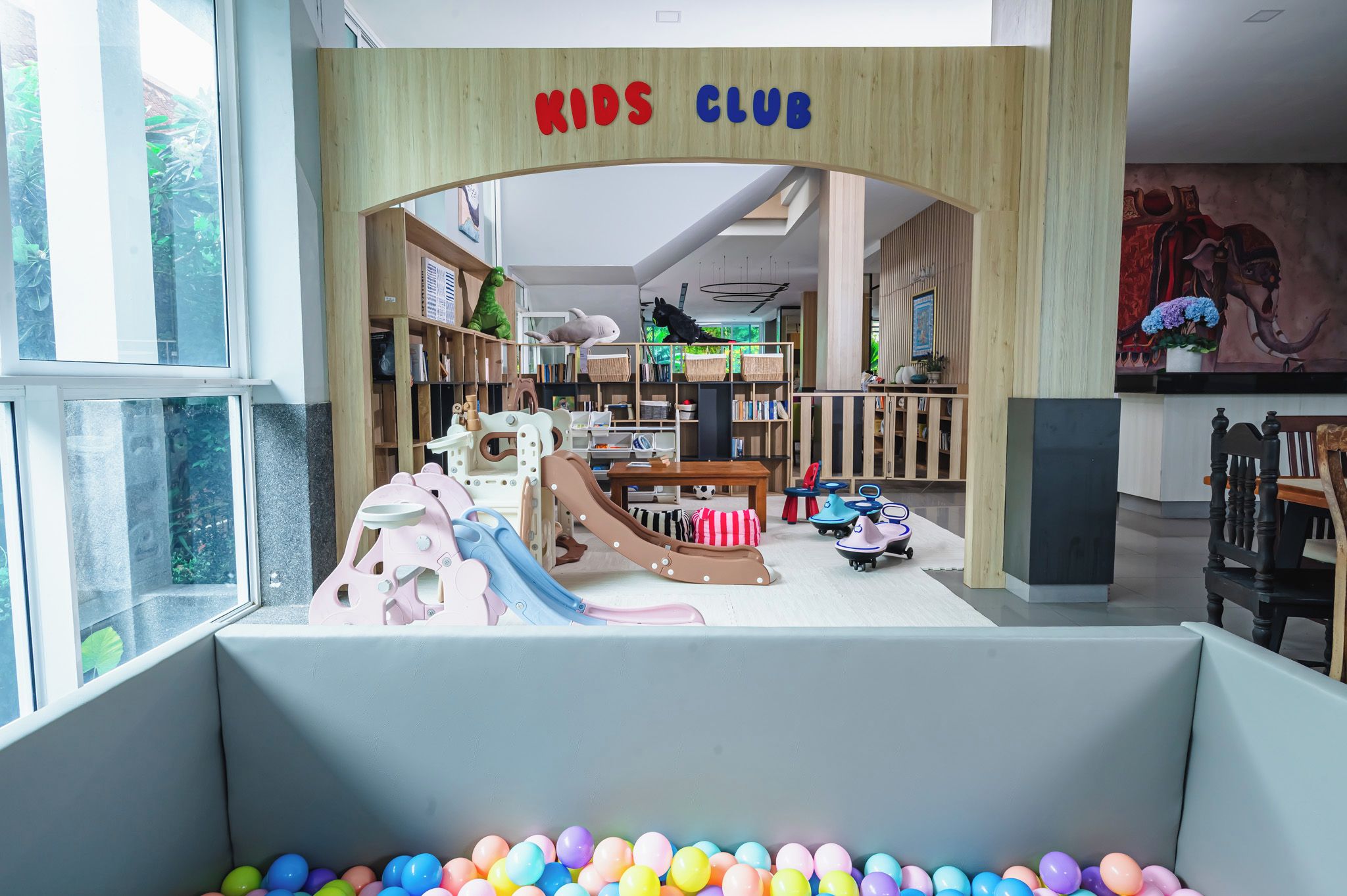 Ein Kinderspielbereich mit Rutsche, Spielzeug und Bällebad.