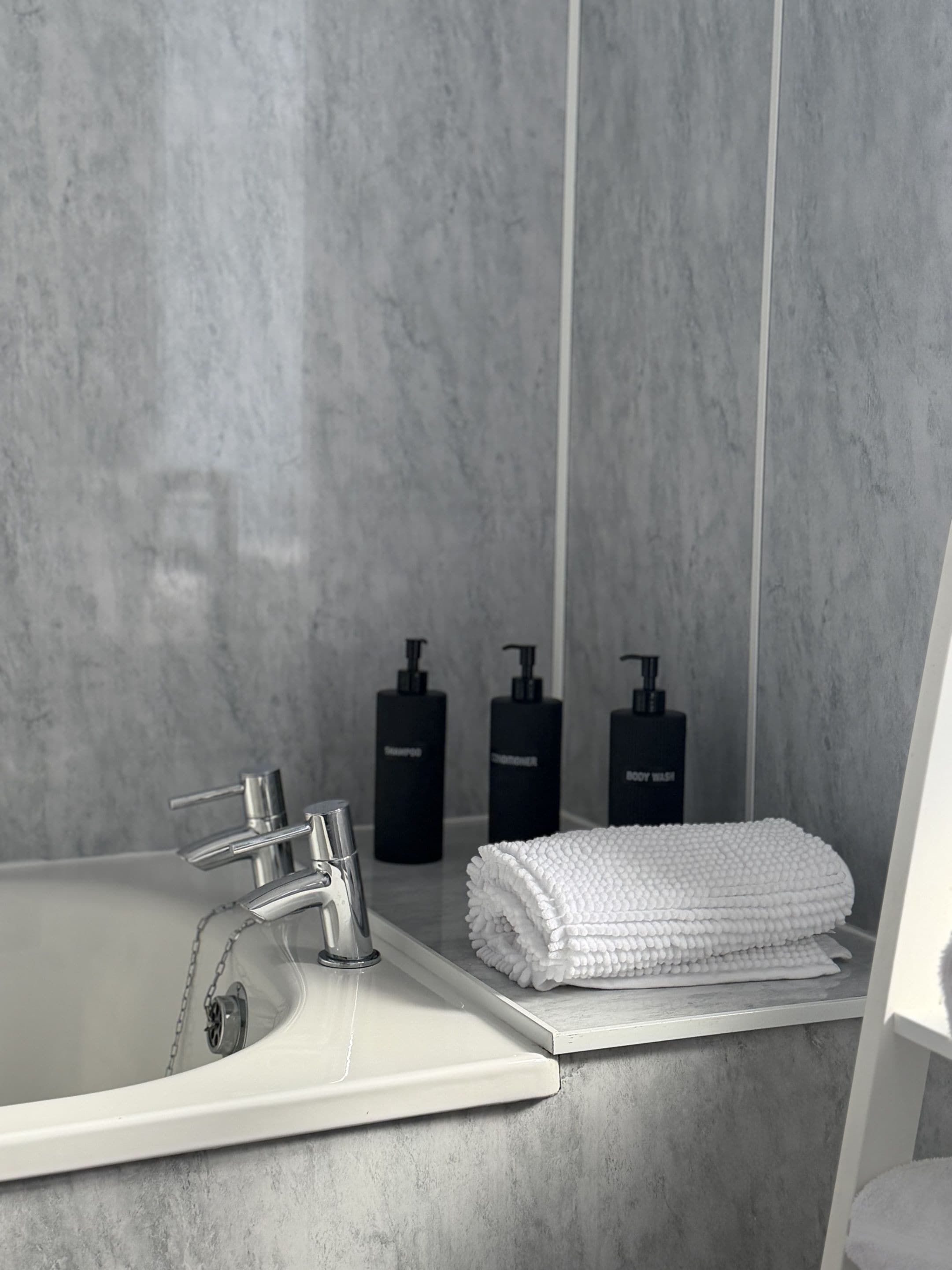 A bathroom with a modern sink, a mirror, and a towel rack.