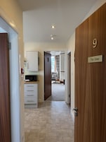 Un pasillo que conduce a una habitación con una puerta de madera marcada con el número 9 y un cartel que dice 'The View'.