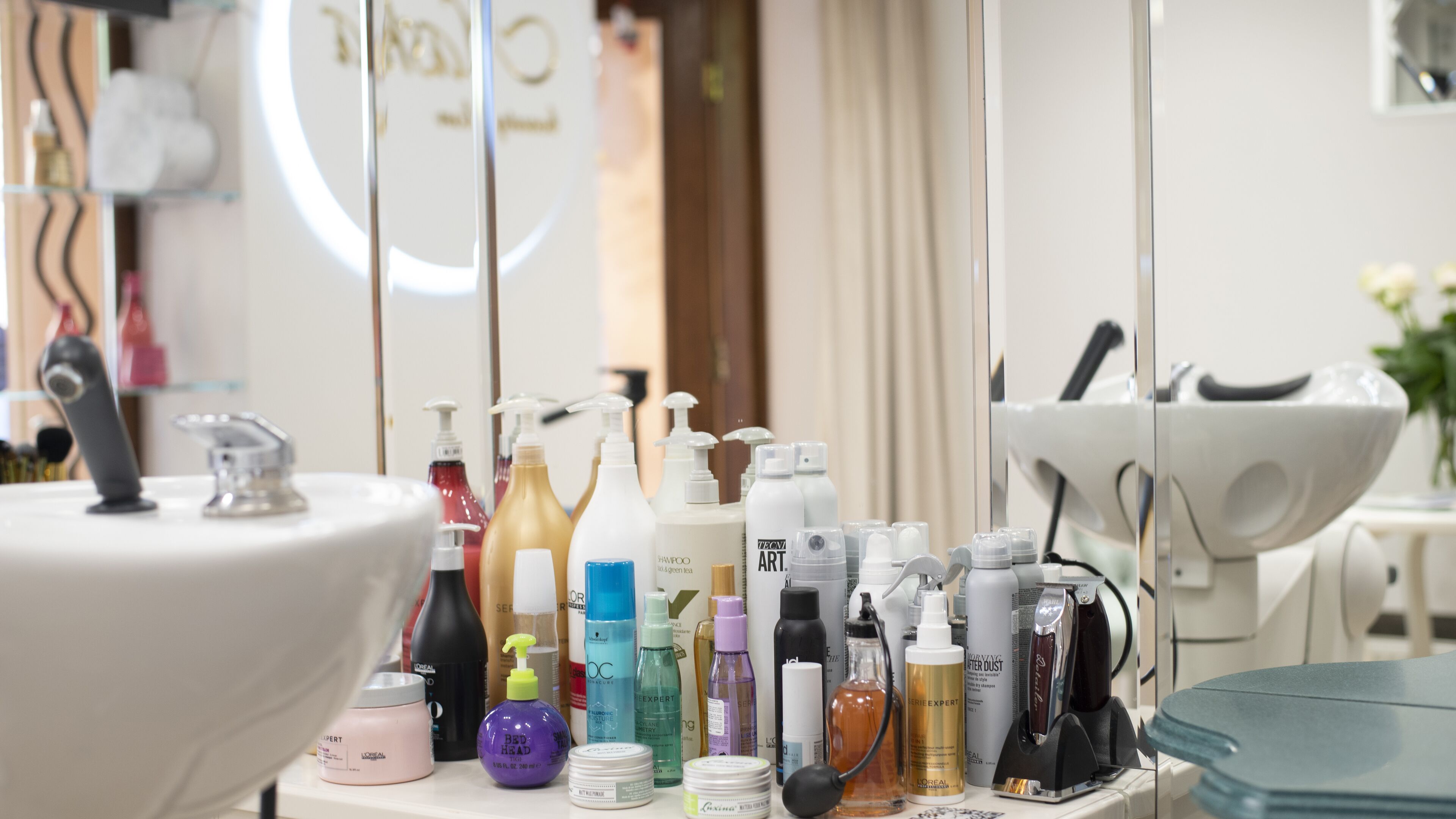 A bathroom vanity with a mirror, a sink, and various toiletries.