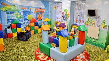Children can play and explore in this vibrant room with a colorful play structure and fun murals.