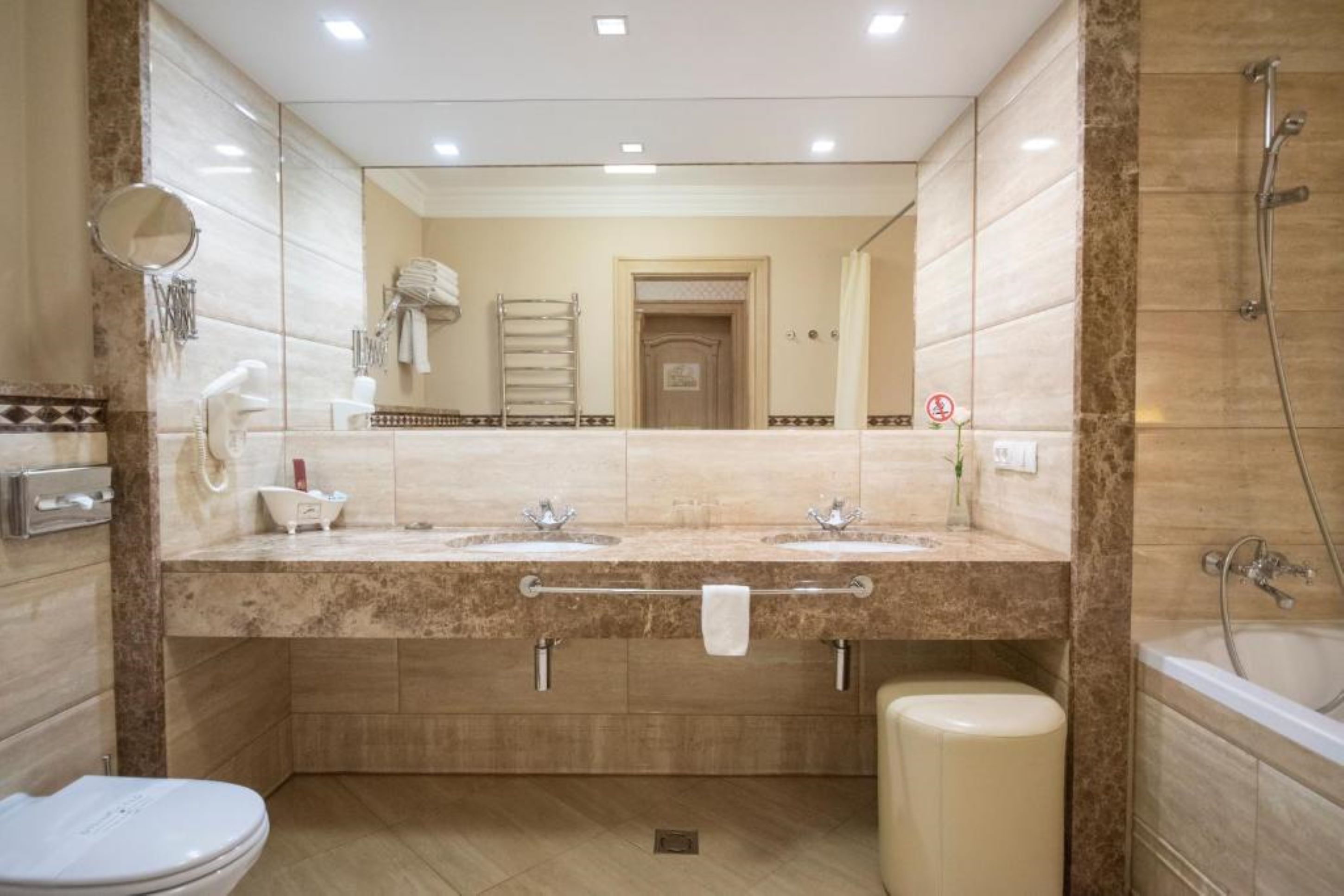Ein modernes Badezimmer mit zwei Waschbecken, einer Toilette, einer Badewanne und einer Dusche.