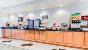 Un espace d’accueil d’hôtel comprenant un comptoir, des distributeurs automatiques et un coin café.