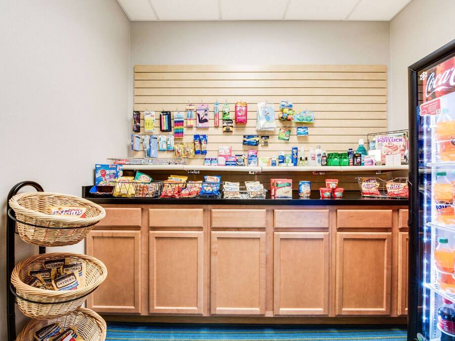 A snack bar with a variety of snacks, drinks, and a Coca-Cola refrigerator.