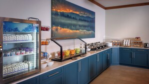 A breakfast bar with a refrigerated display, a painting of a landscape, and a variety of food items. - Delta Hotels by Marriott Huntington Mall (Barboursville)