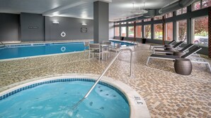 An indoor swimming pool with a tiled floor, lounge chairs, and a pool ladder. - Delta Hotels by Marriott Huntington Mall (Barboursville)