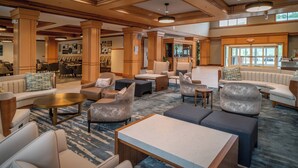A spacious lobby with a mix of seating options including sofas, armchairs, and a coffee table. - Delta Hotels by Marriott Huntington Mall (Barboursville)