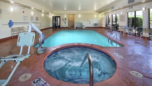 Un área de piscina con jacuzzi, sillas de descanso y un tobogán de agua.