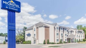 Suuri Microtel Inn & Suites by Wyndham -hotellin kyltti, useita kerroksia ja suuri pysäköintialue.