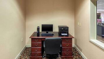 A small office with a desk, computer, printer, and chair.