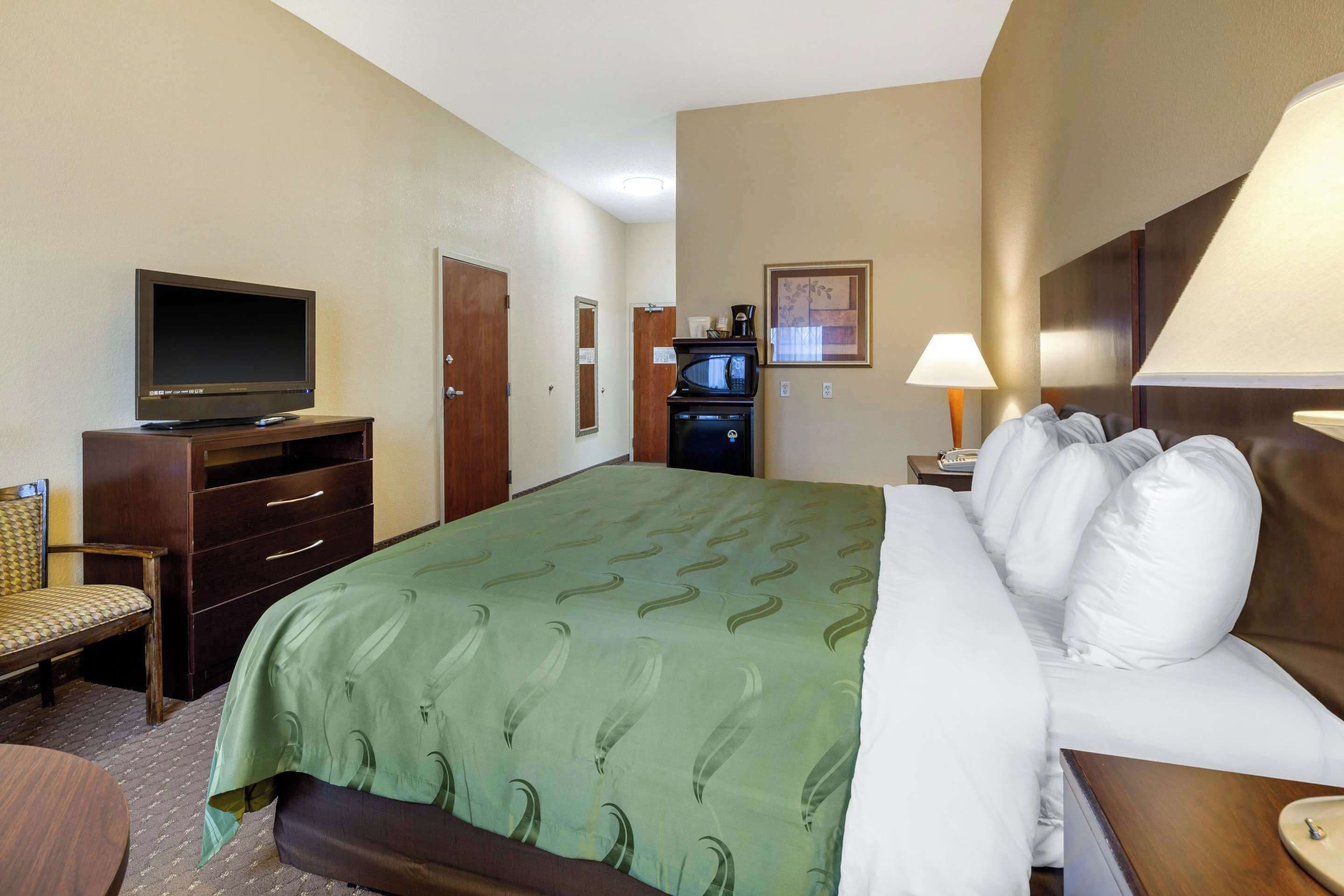 Une chambre d’hôtel équipée d’un lit, d’une télévision, d’un bureau et d’une chaise.