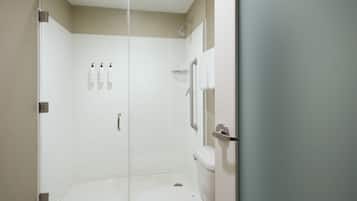 A modern bathroom with a glass shower enclosure, a toilet, and a sink.