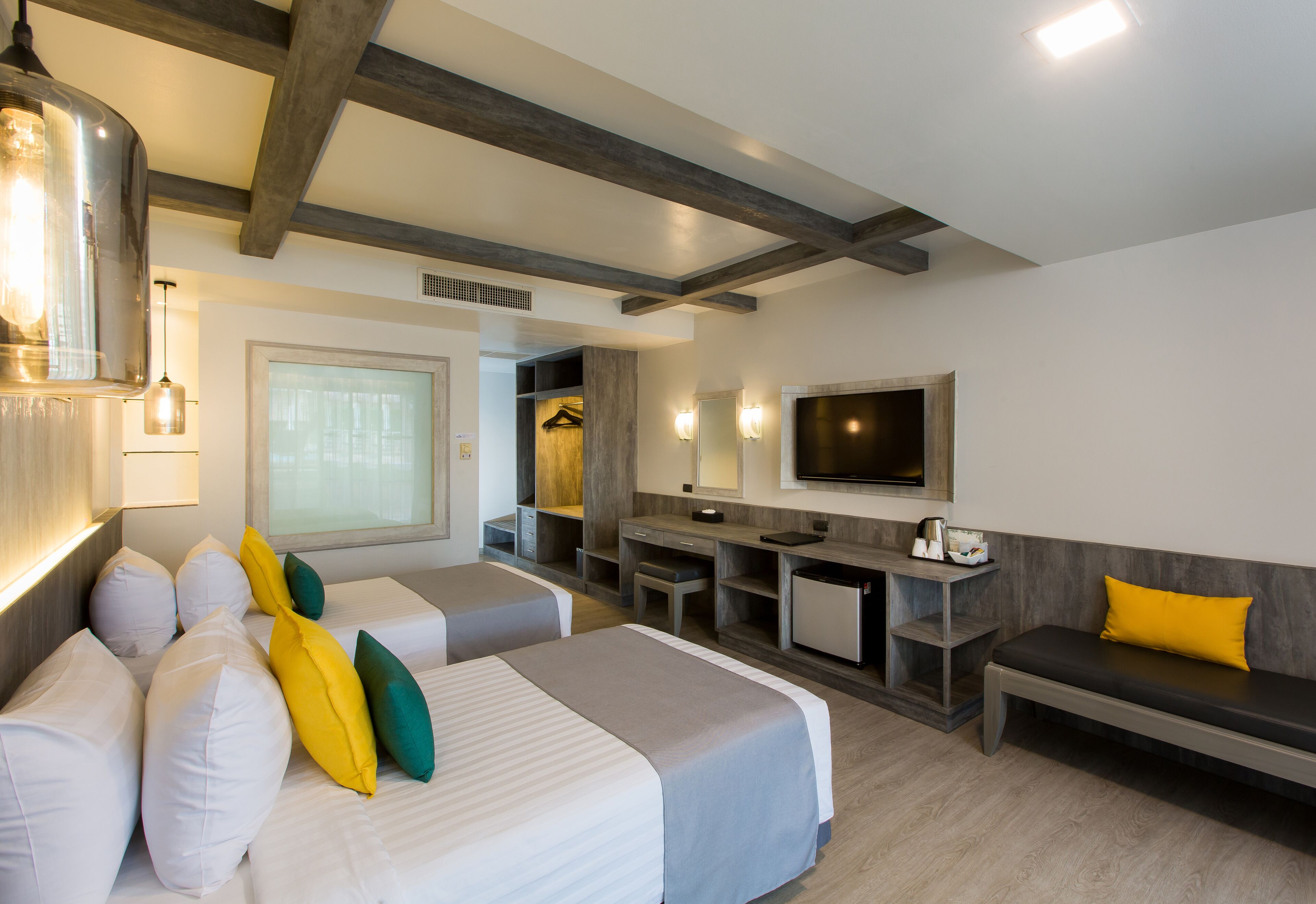 Ett hotellrum med två sängar, ett skrivbord, en TV och en sittgrupp.