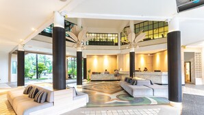 A spacious lobby with a reception desk, seating area, and a view of the outdoors. - Coconut Village Resort (Patong)
