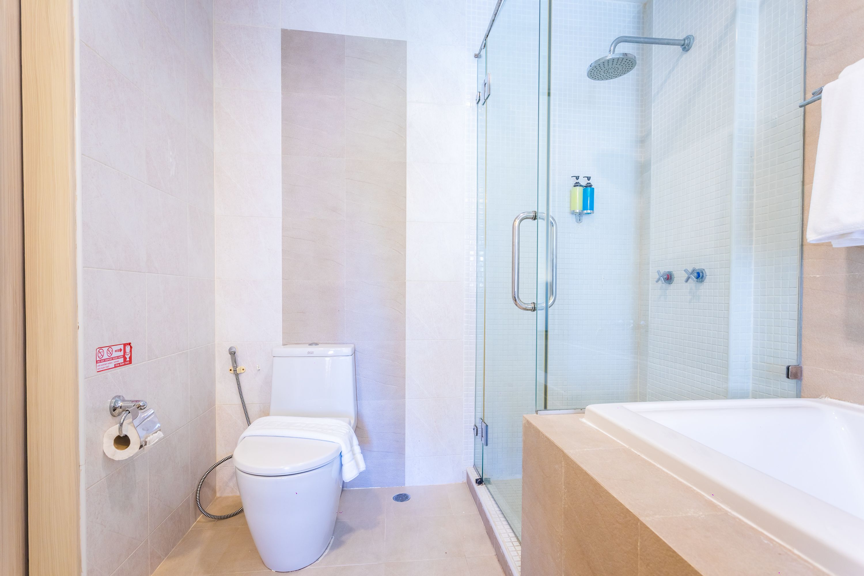 Un baño moderno con cabina de ducha de vidrio, una bañera y un inodoro.