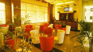 A lobby with red and white chairs, a bar area, and large windows. - Camela Hotel & Resort (Hai Phong)