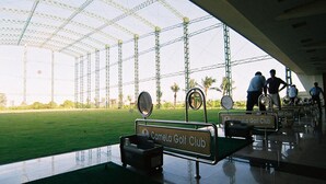 A golf club with a large open space, a green field, and a covered area with a roof structure. - Camela Hotel & Resort (Hai Phong)