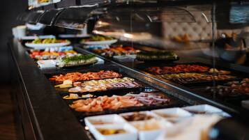 A buffet with various food items and condiments.