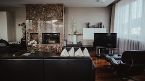 Una sala de estar moderna con chimenea, un sofá de cuero y un televisor de pantalla plana.