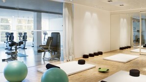 A modern gym with exercise equipment, mats, and large exercise balls.