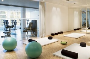 A modern gym with exercise equipment, mats, and large exercise balls.