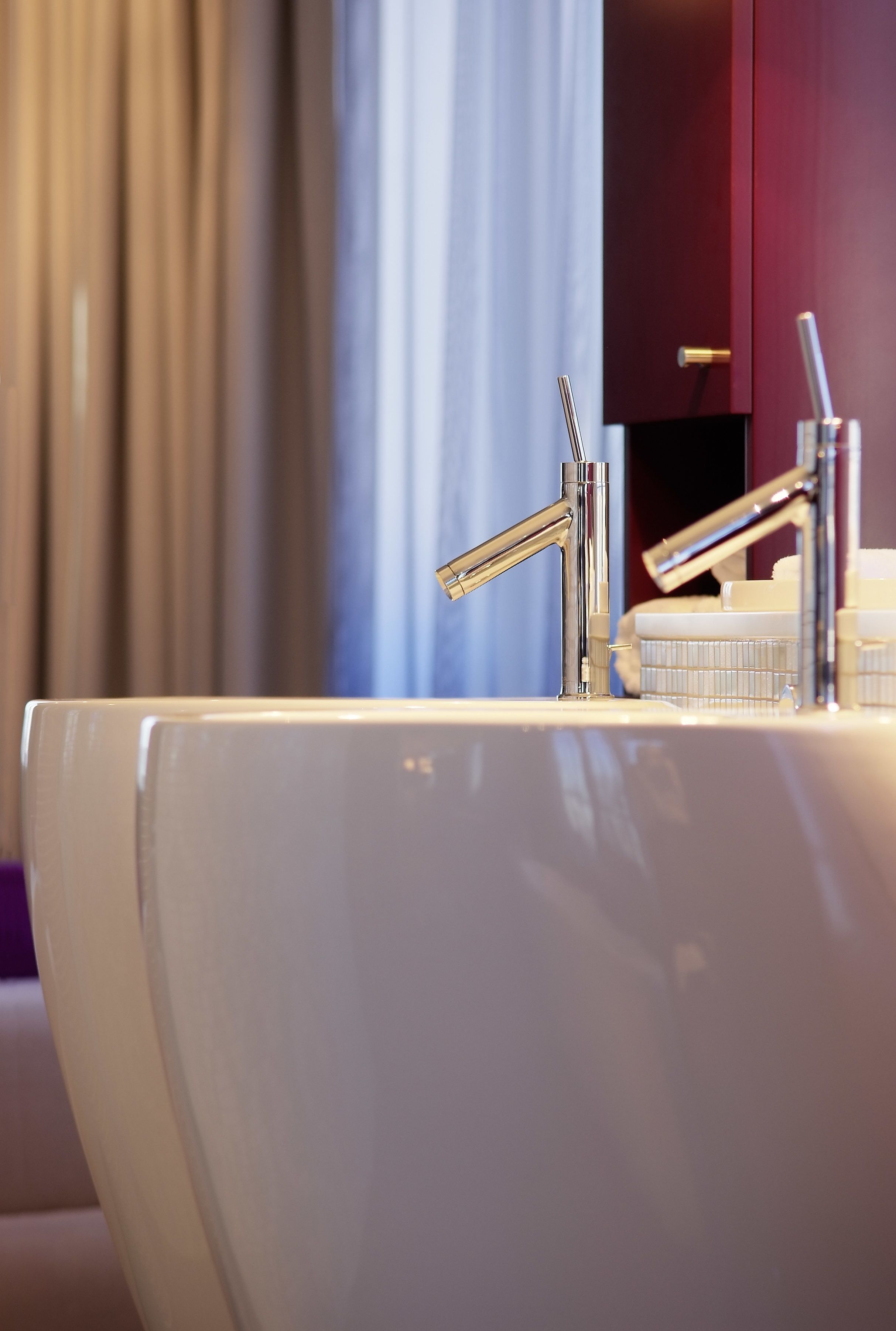 Un baño moderno con un lavamanos blanco, grifo cromado y un espejo.
