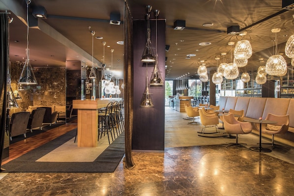 A modern interior with a bar area, seating, and decorative lighting.