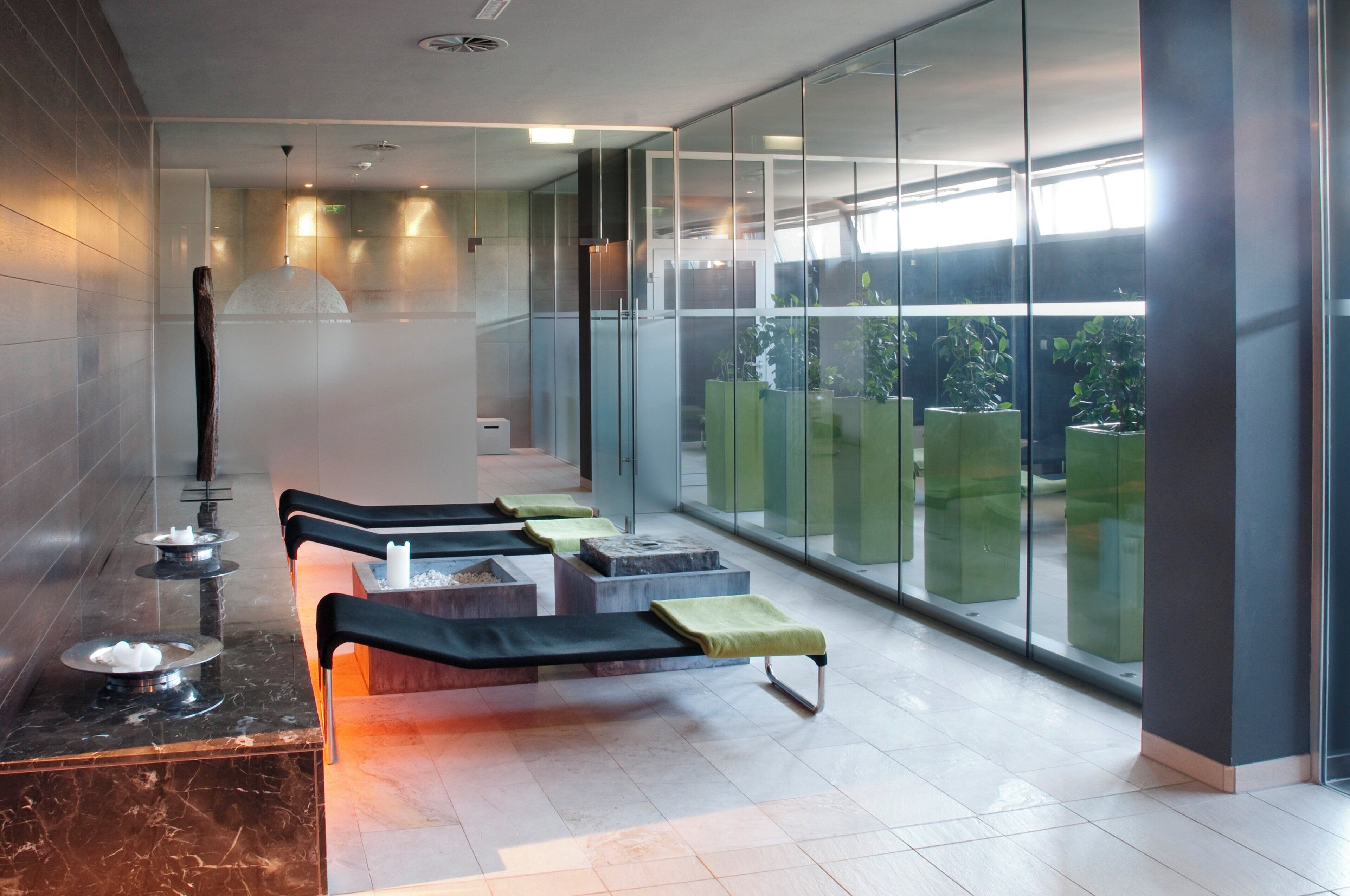 A modern spa area with seating, a sauna, and a view through large windows.