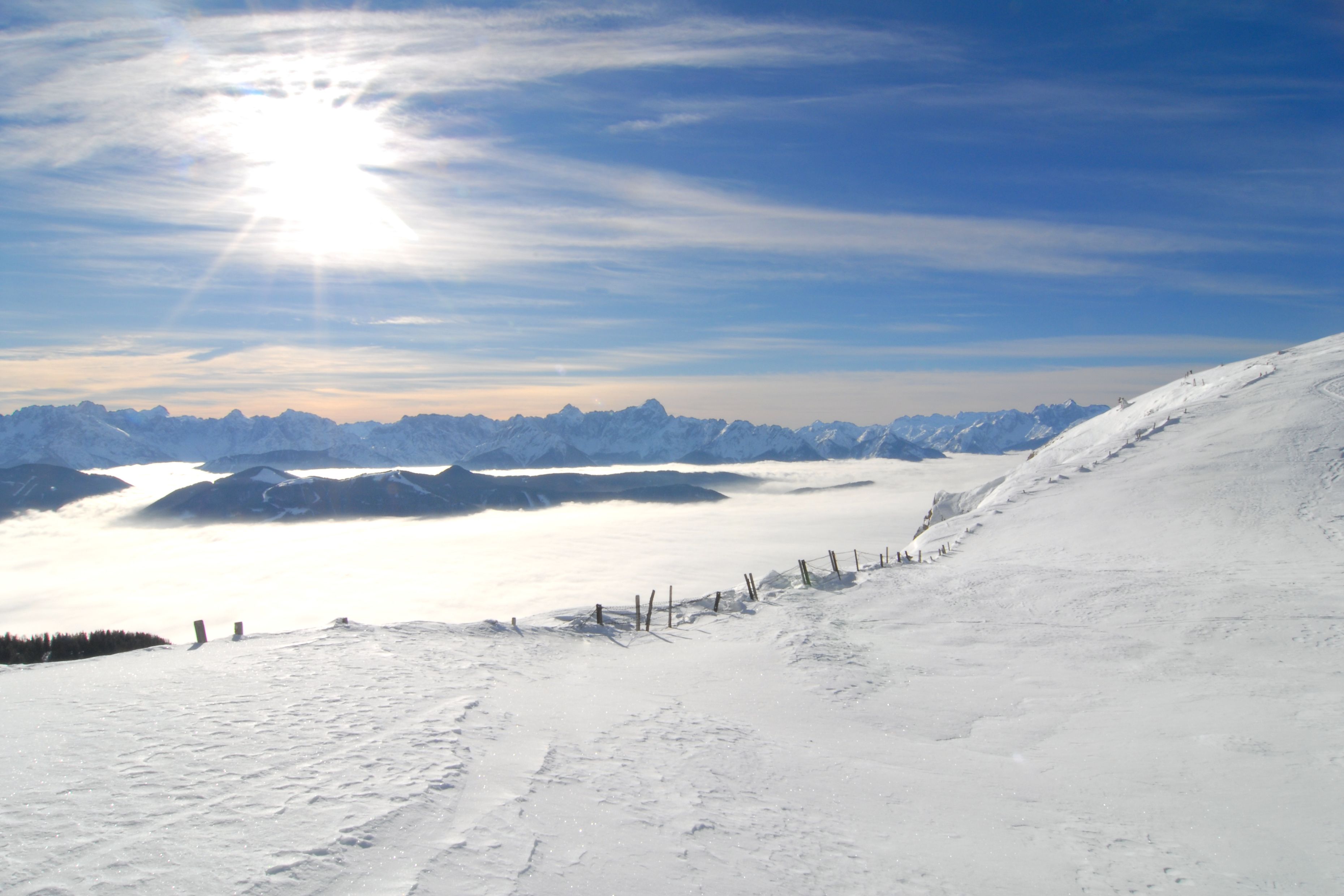A snowy mountain landscape with a clear sky and distant mountains.