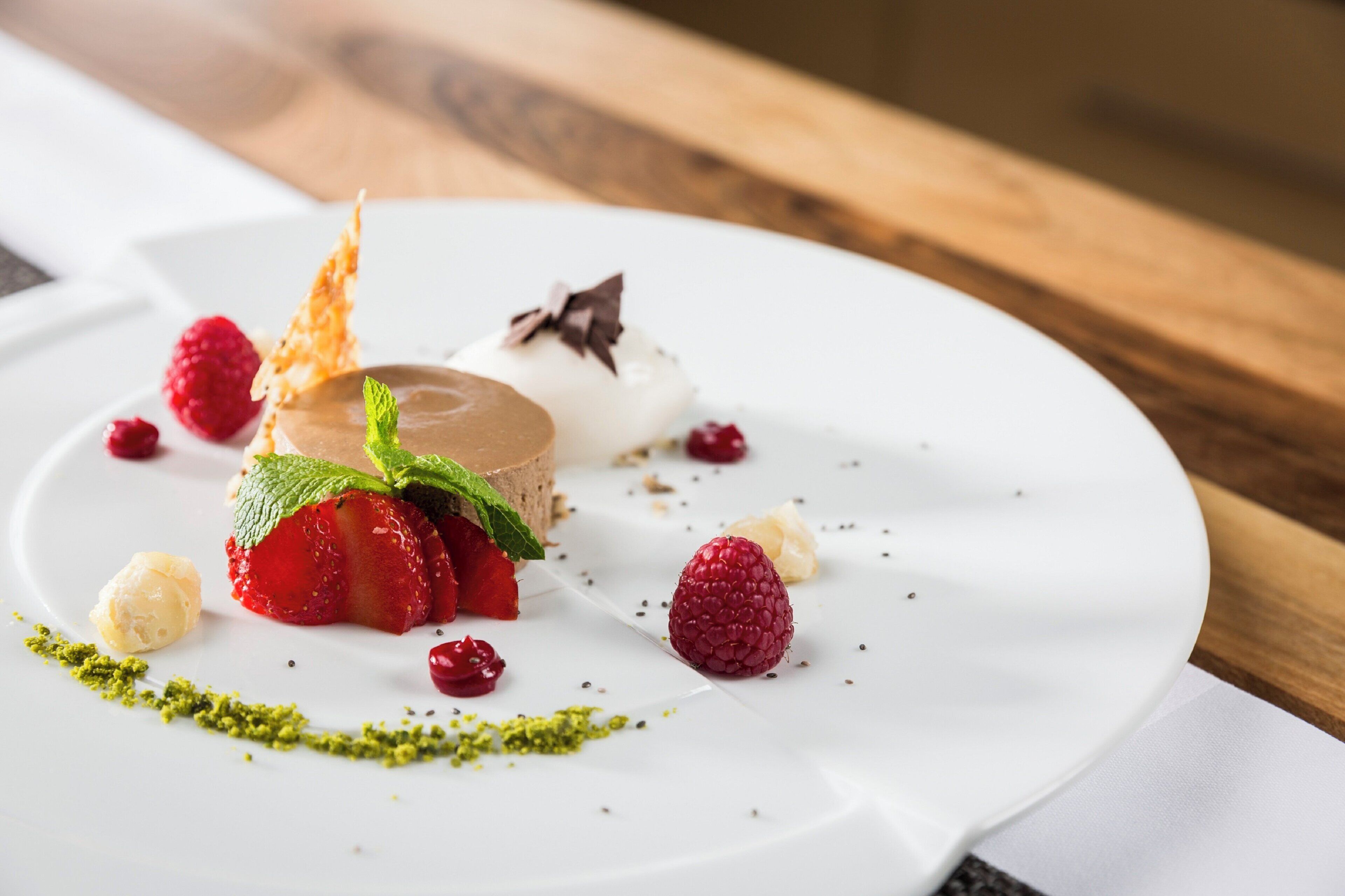 Ein Dessertteller mit Schokoladenmousse, Erdbeeren, Himbeeren und Minzblättern.