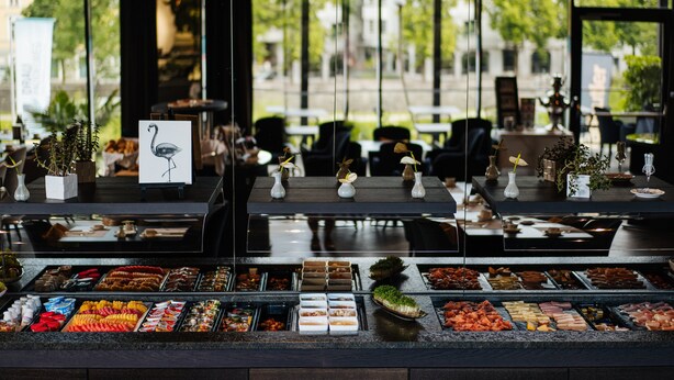A buffet with various food items and a swan decoration. - voco Villach by IHG (Villach)