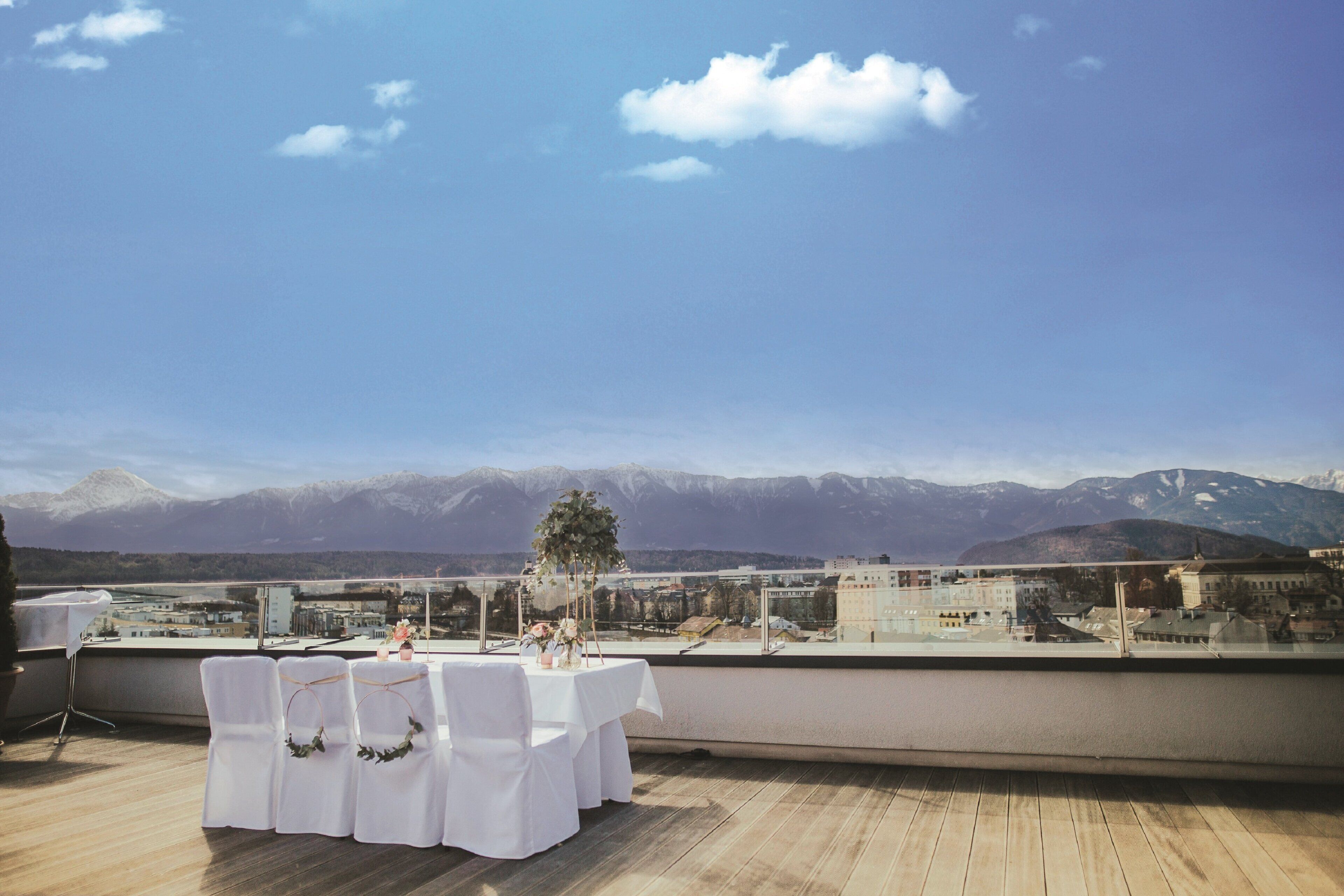 Terraza en la azotea con una mesa preparada para comer, con vistas a un paisaje montañoso.