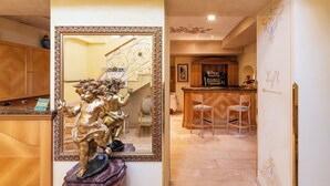 A hotel lobby with a statue, a mirror, a staircase, and a reception desk. - Boutique Hotel Dieci (Milan)