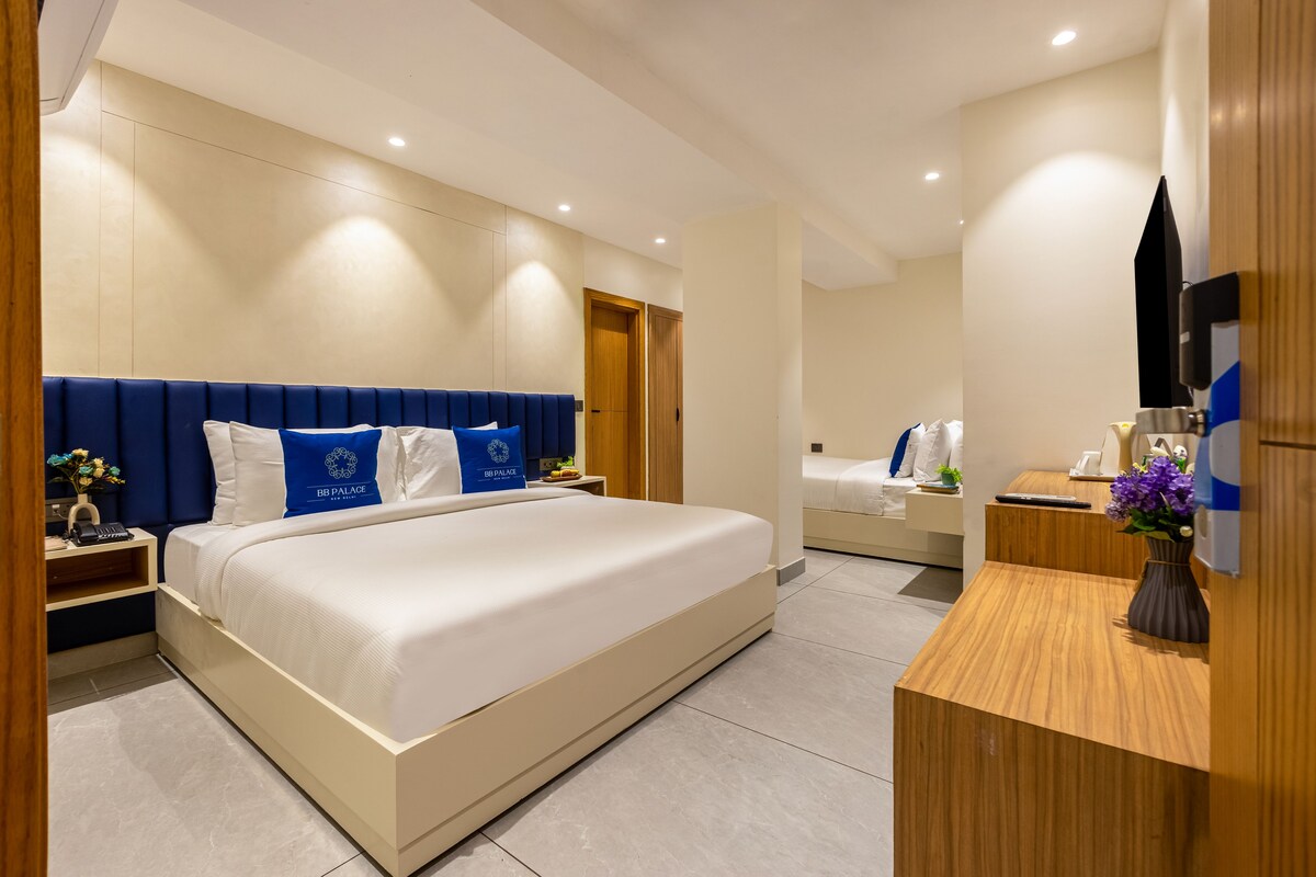 Ein Hotelzimmer mit einem großen Bett, Nachttischen, einem Schreibtisch und einem Spiegel.
