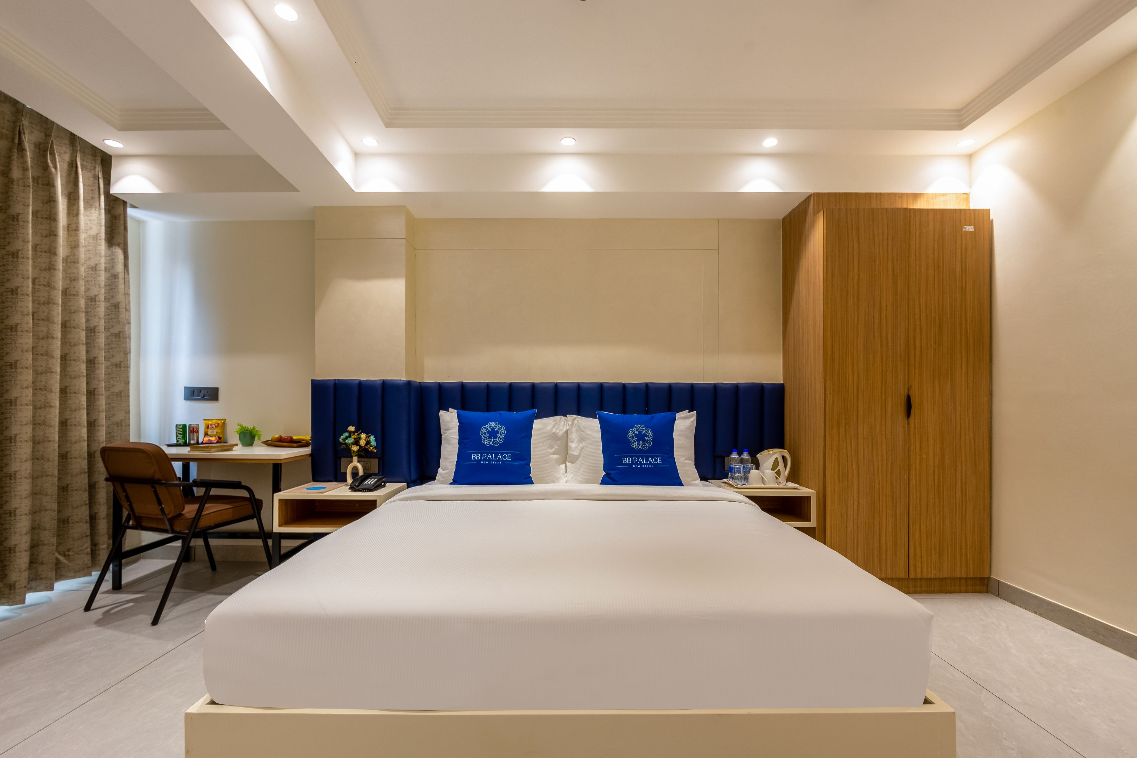 Ein Hotelzimmer mit einem großen Bett, einem Schreibtisch, einem Stuhl und einem Kleiderschrank.