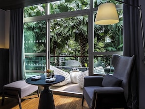Une pièce moderne dotée d’une grande fenêtre, d’une table ronde, d’un canapé et d’une chaise.