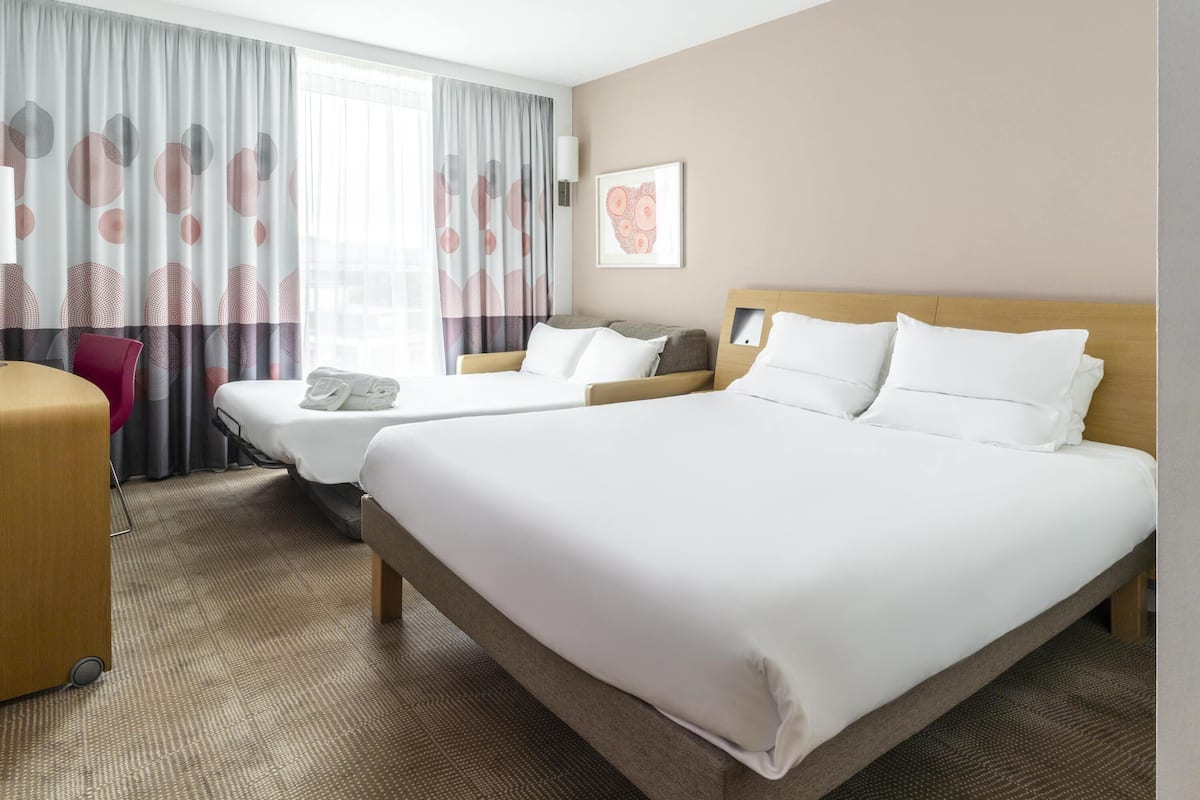 Una habitación de hotel con dos camas, un escritorio y una silla.