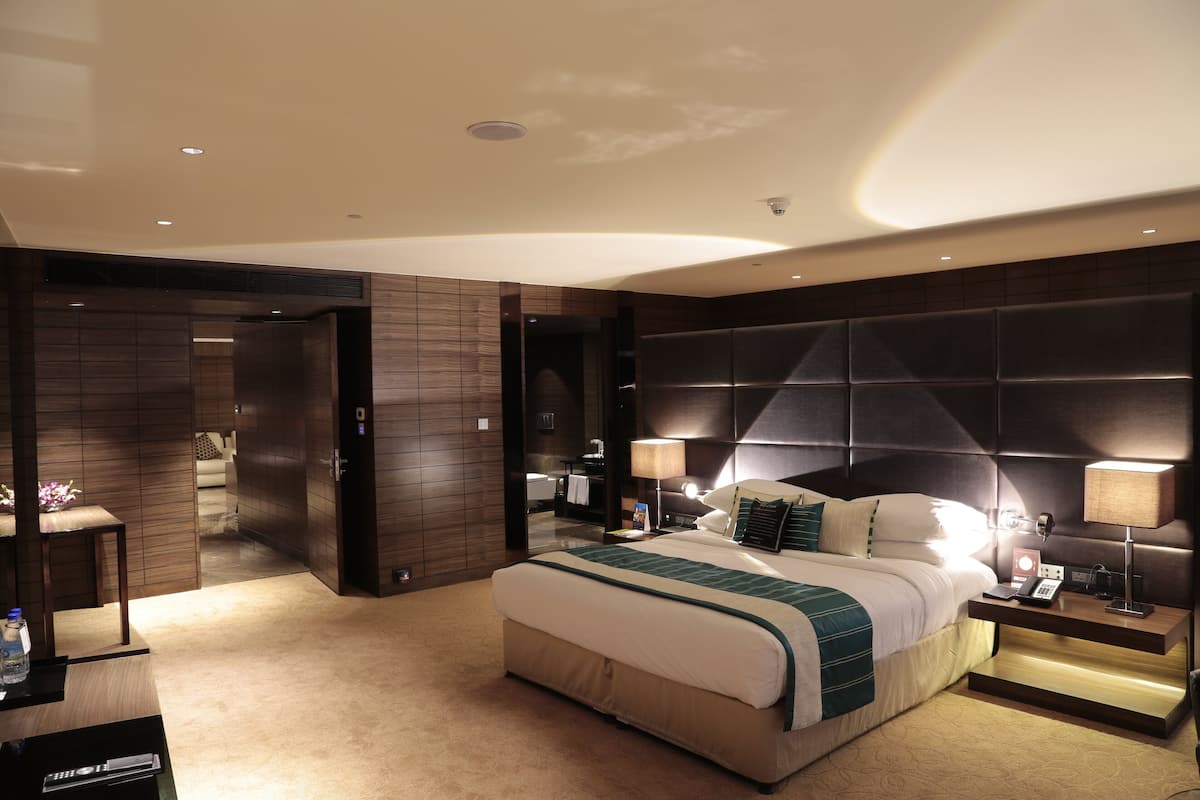 Une chambre d’hôtel moderne avec un grand lit, des lampes de chevet, une table de chevet et une vue sur la salle de bain.